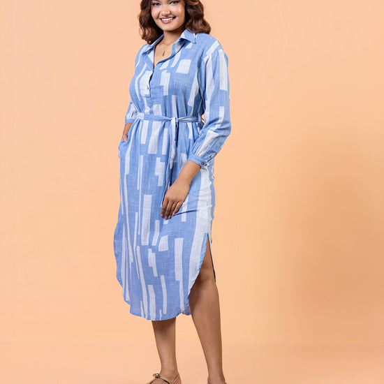 Full shot of model posing in Cinnamon Isle blue linear domino print midi shirt dress