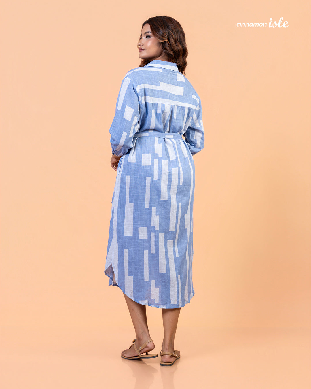 Side view of Cinnamon Isle blue domino patterned collared shirt dress showing tie belt